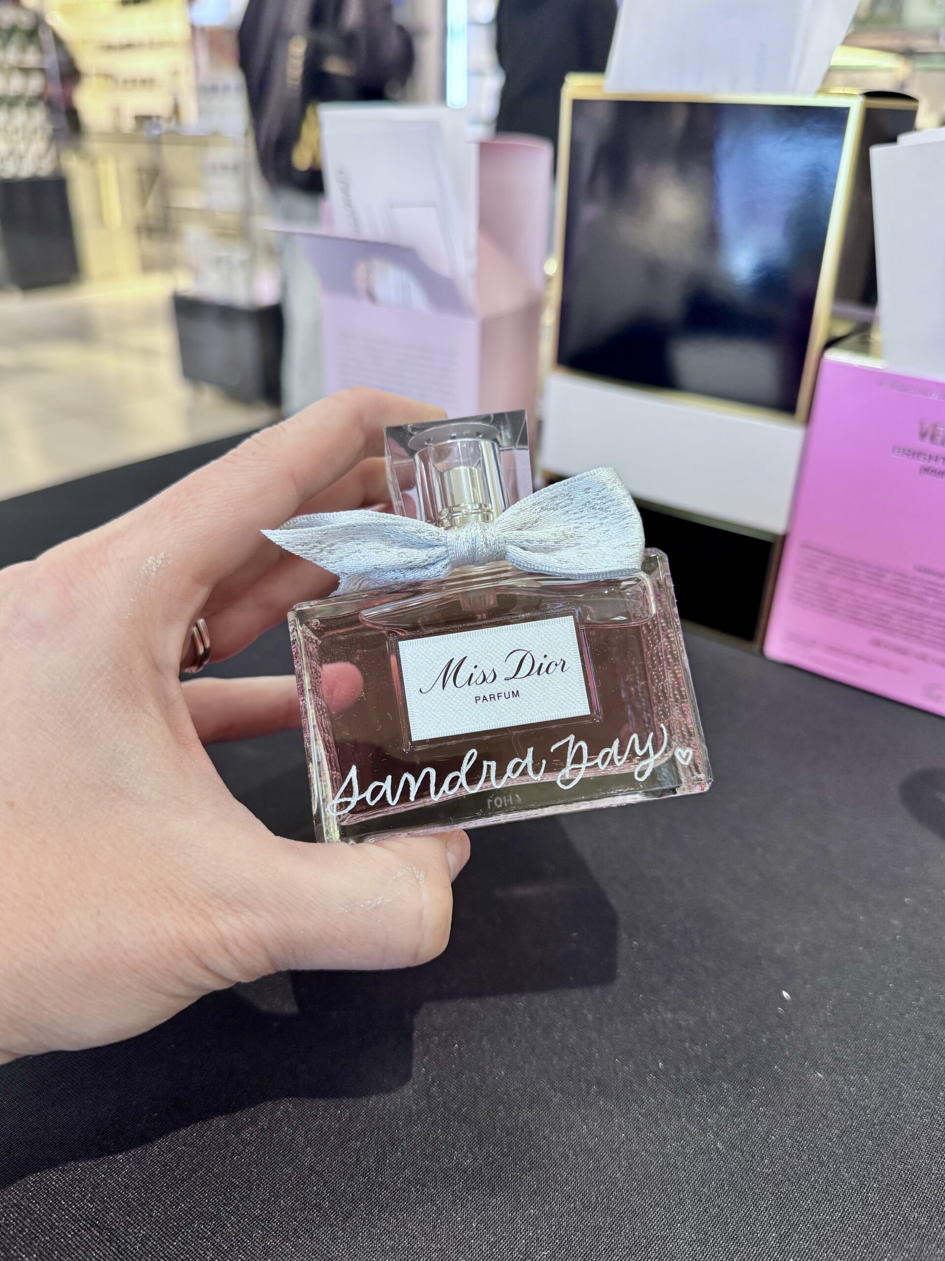 Glass-Spray-Bottle-Silver-Bow-Miss-Dior-Parfum-Calligraphy-Engraved-Sandra-Day-Live-Event-Artist-KPCalligraphy-Nordstrom-Atlanta-Georgia-Mothers-Day-2025-scaled.jpg